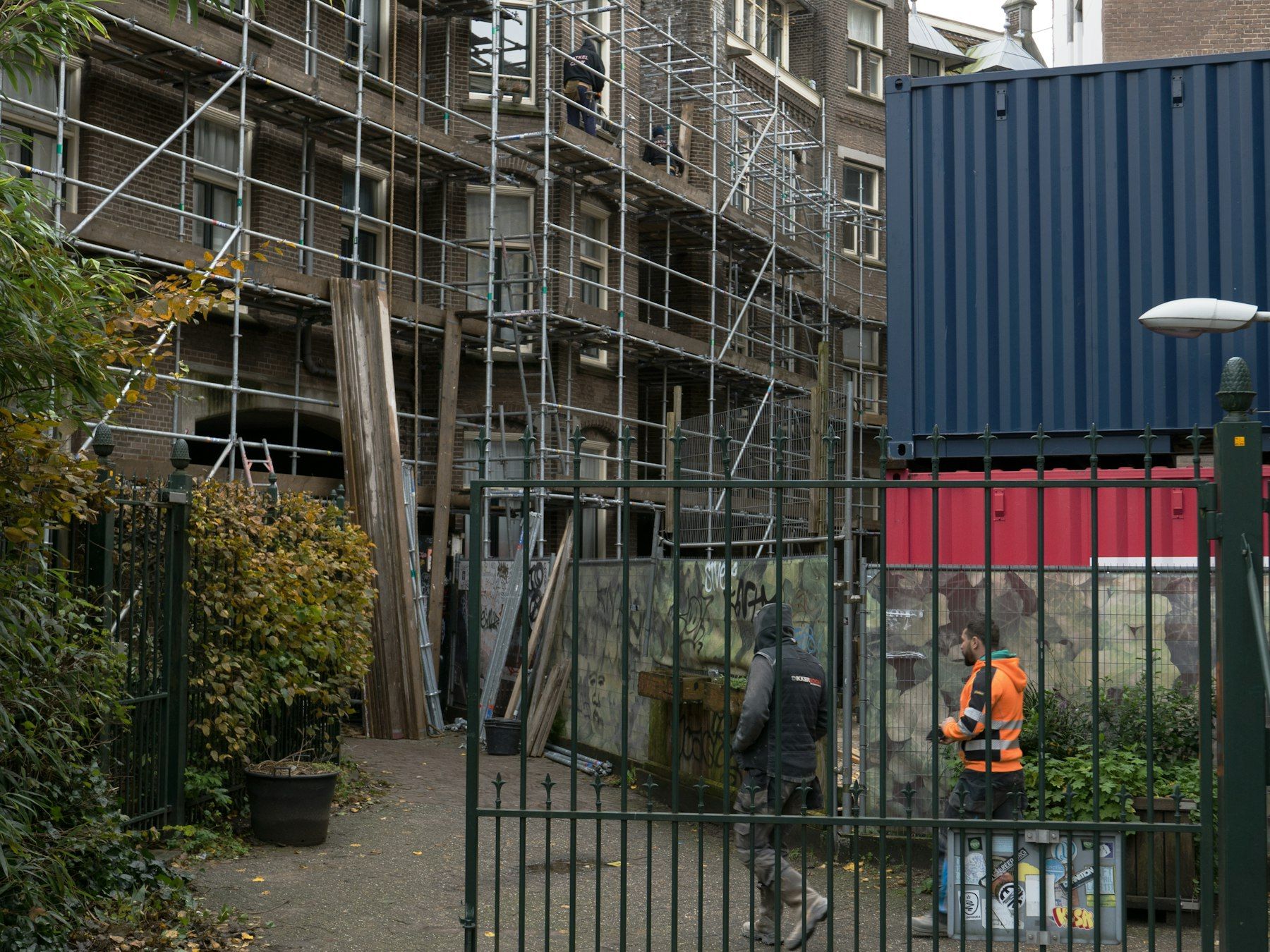 Handwerker vor einem eingerüsteten Gebäude